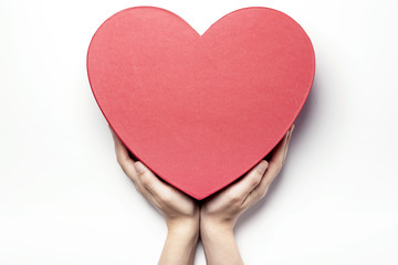 Woman hand hold a red heart gift box isolated white.
