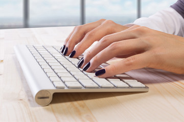 Woman with perfect manicure typing on keyboard