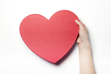 Woman hand hold a red heart gift box isolated white.