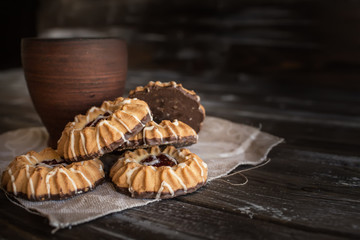 clay cup on a napkin of burlap, lies next to Cookies