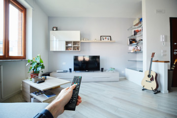 Ragazzo in soggiorno accende la tv