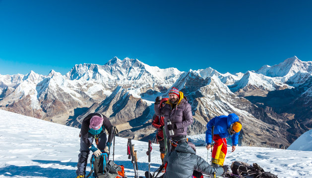 Group of Mountain Climbers preparing for ascent on high Peak