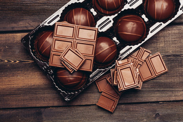 chocolate bar and cakes in a package, wooden background
