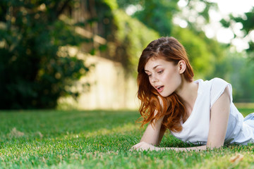 Naklejka na ściany i meble woman lies on the grass in the park
