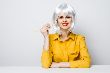 woman with chopsticks, wig and yellow shirt