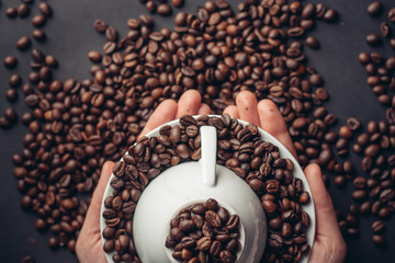 an inverted mug in a saucer, coffee beans