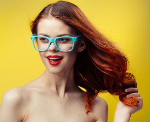 beautiful woman with red lips touches her hair with her hands, blue glasses