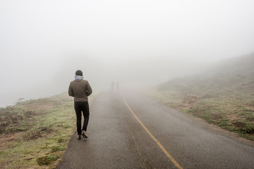 Lone man walking through the white fog