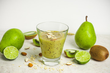 Kiwi smoothie with pears, oats, limes and almond on the wooden background
