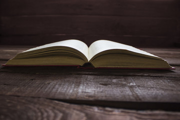 Open red book on old wooden table