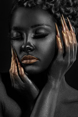 girl covered with black paint with gold lips and gold at your fingertips