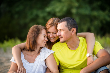 Fototapeta premium Smiling adult daughter hugging her parents. Family bonding.