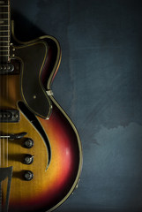 Obraz premium Close-up of old electric jazz guitar on a dark blue background