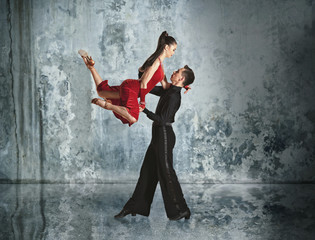 Fototapeta na wymiar Beautiful couple in the active ballroom dance on wall