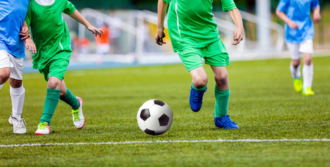 Football Player Running with the Ball on the Pitch. Footballers Kicking Football Match on the Pitch. Young Teen Soccer Game. Youth Sport Background