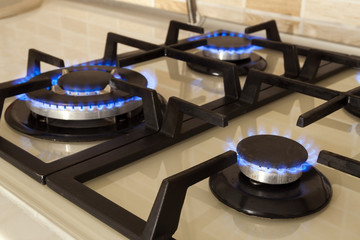 Closeup shot of blue fire from domestic kitchen stove. Gas cooker with burning flames propane gas.