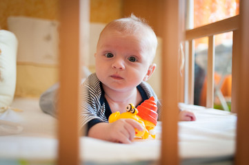 little baby boy lying in a crib