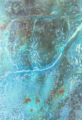 A rusty old metal plate with cracked blue gloss paint