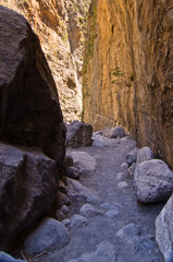 Fototapeta na wymiar Pathway through iron gate, narrowest part of Samaria gorge, island of Crete, Greece