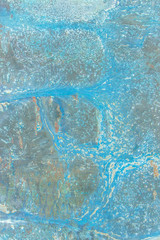 A rusty old metal plate with cracked blue gloss paint