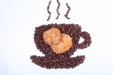 Coffee beans in the form of cup of coffee with cookie on the white background