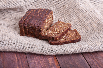 Sliced black bread on the old wooden plank