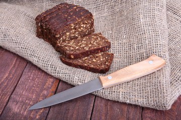 Sliced black bread on the old wooden plank