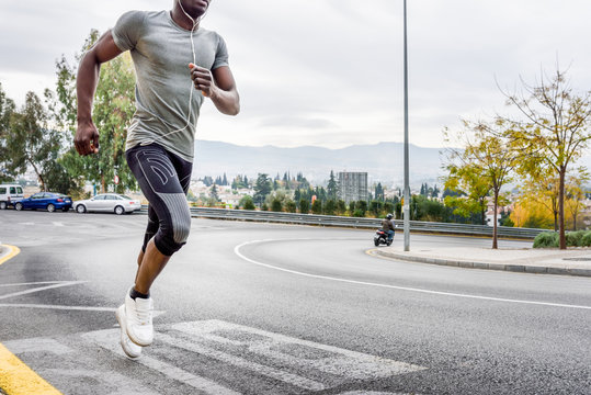 Black Man Running Outdoors In Urban Road.