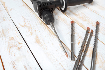 Electric hammer drill lies on a wooden table