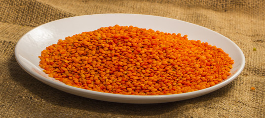 ripe fruits of red lentils on a white plate