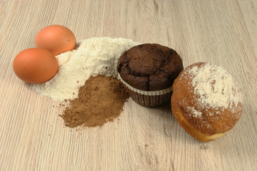 Chocolate chip muffin cake eggs closeup on wooden background