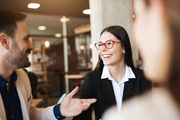 Portrait of smiling partners in full formal suits looking at each other, discussing new ideas. Business concept brainstorming solving, talking outside the office at cafe bar.