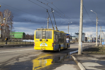 Modern yellow trolley bus on the road -  back view