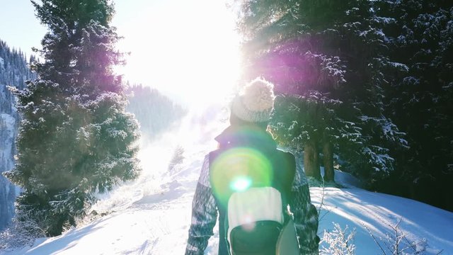 Footage of snowboarder woman adventure, walking to snowy mountains