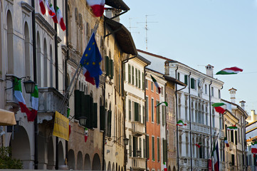 The italian flags among historic buildings in Pordenone. Italy