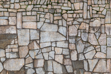 Textured gray wall with cracks and moss
