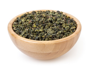 Dry green oolong tea in wooden bowl isolated on white background with clipping path
