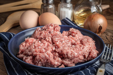 Minced meat on wooden background.