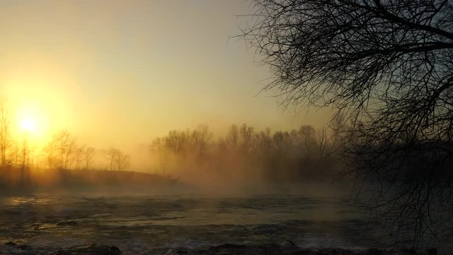 Flowing river with sun and fog