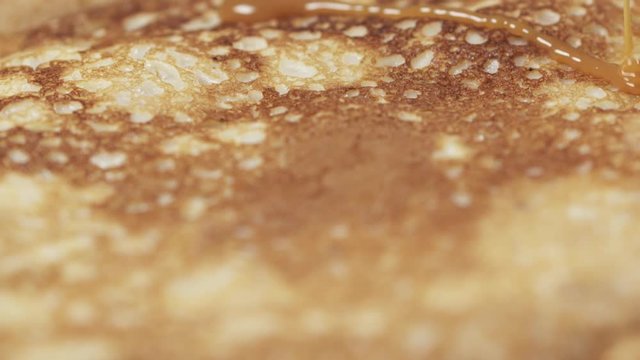 Slow motion of caramel sauce pour over blini closeup, 180fps prores footage