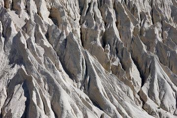 Blurred rain flows a sand slope of the mountain.