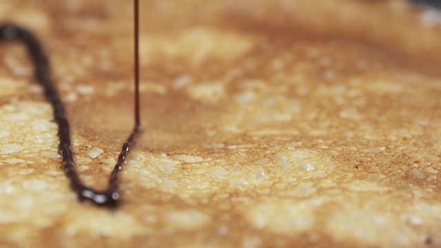 Slow motion of chocolate sauce pour over blini closeup, 180fps prores footage