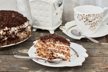 Layer cake with chocolate shavings and a cup of tea. horizontal