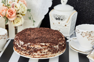 Layer cake with chocolate shavings and a cup of tea. horizontal