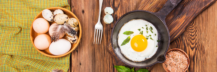 Rural breakfast with eggs and spices on a wooden background