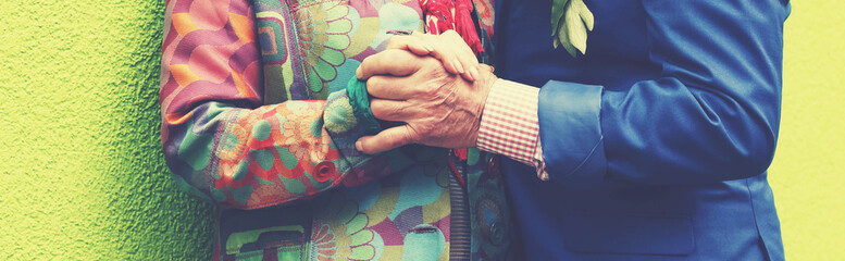 Elderly man passionately in love is explained by an elderly lady on a green wall. Love and passion.