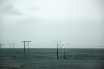 Icelandic electric poles, vast field, rain cloud