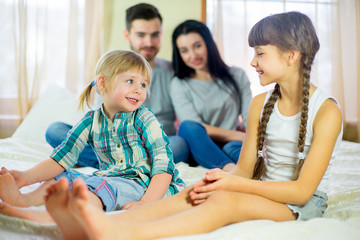family posing on the bed in the hotel