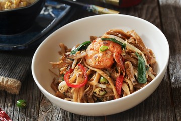 Shrimp Pad Thai served in a white bowl, selective focus