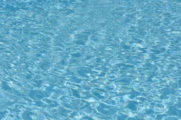 Blue and bright water surface and ripple wave in swimming pool